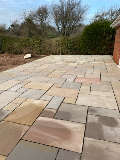 professionally laid Indian sandstone patio creating a spacious outdoor seating area
